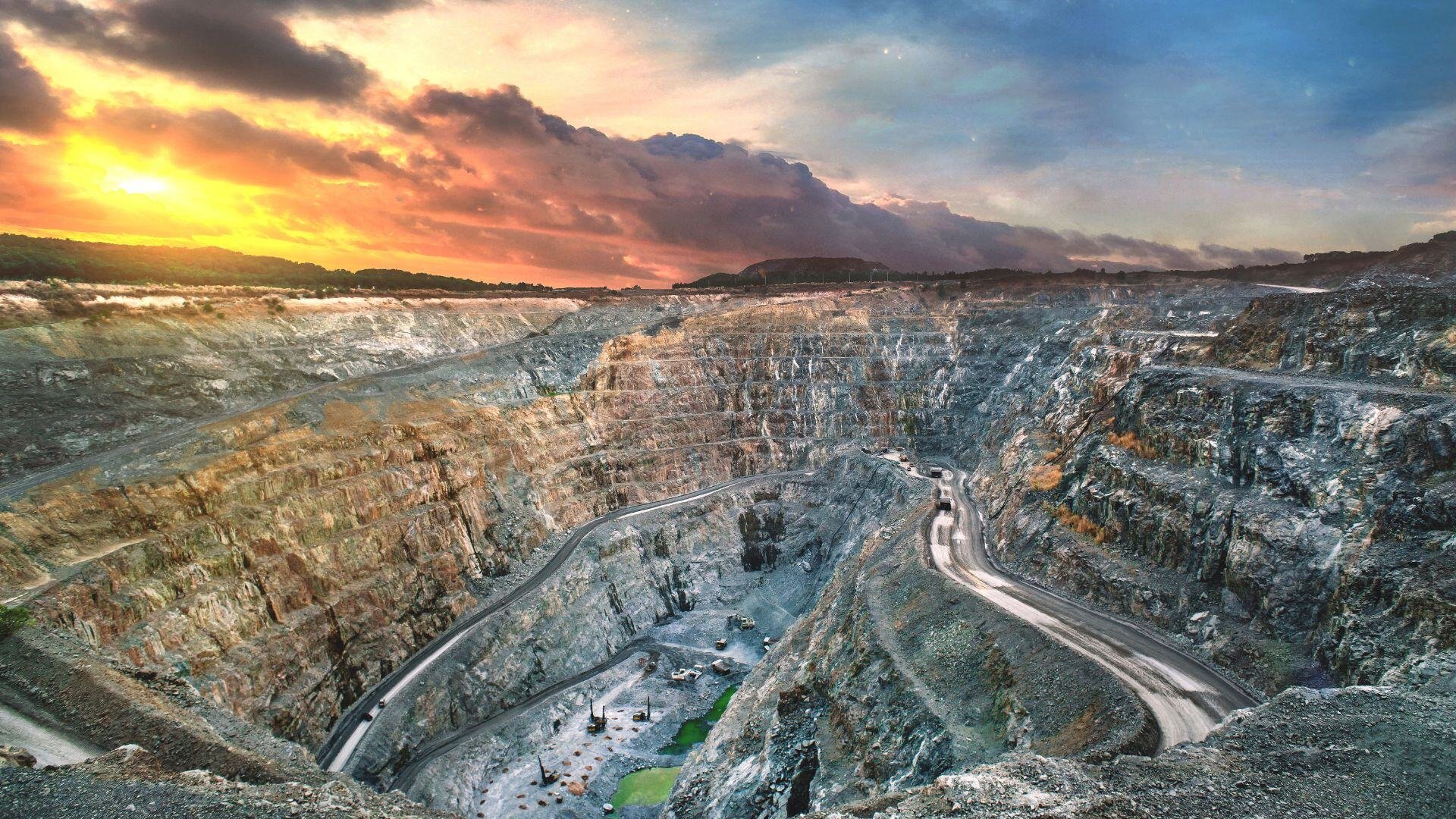 A mining operation in Northern Ontario, featuring heavy machinery at work in a rugged landscape under a clear sky.
